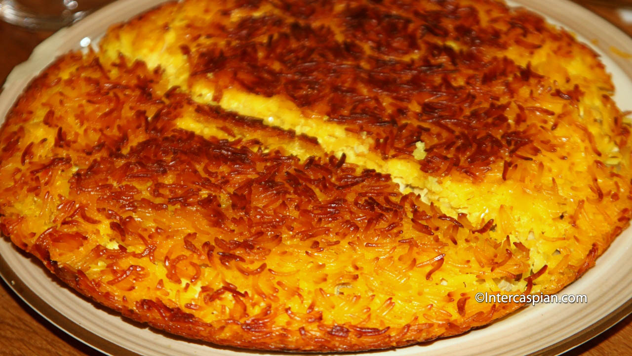 Tachin, layered chicken and rice mixed with egg yolks, yoghurt and saffron encapsulated in crunchy and buttery rice crust